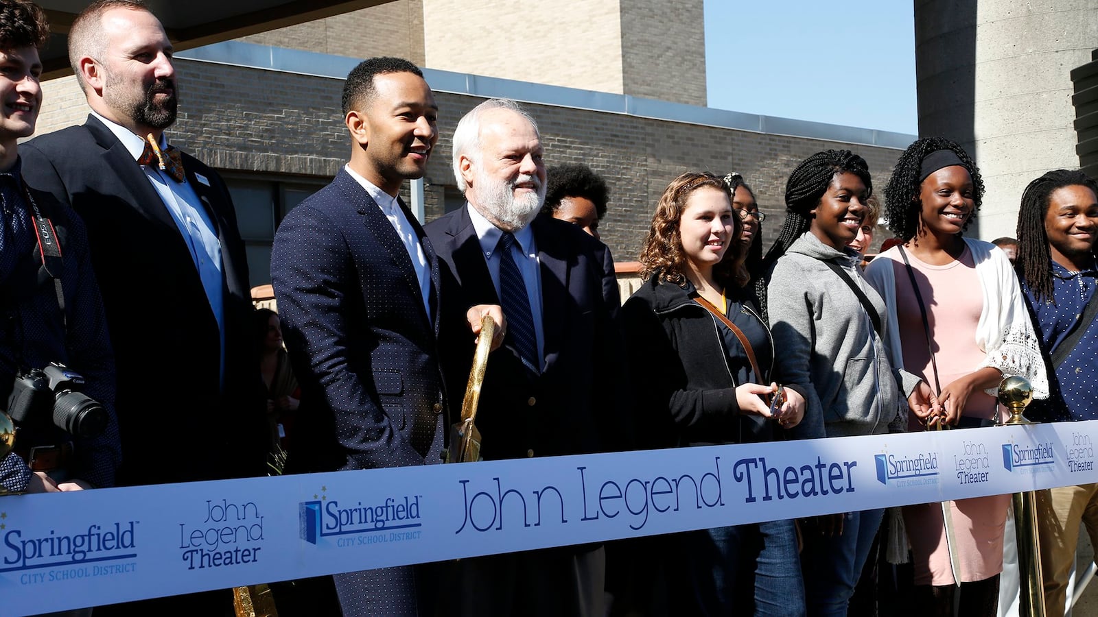 John Legend, center, joins Springfield City and School officials along with students in cutting the ribbon for the John Legend Theater in 2016. BILL LACKEY/STAFF