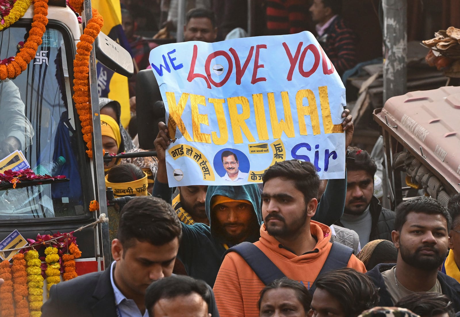 A supporter of Aam Aadmi Party (AAP) holds a placard during a road show of his party's national convener Arvind Kejriwal for Delhi state election campaign in New Delhi, India, Monday, Feb. 3, 2025. (AP Photo)