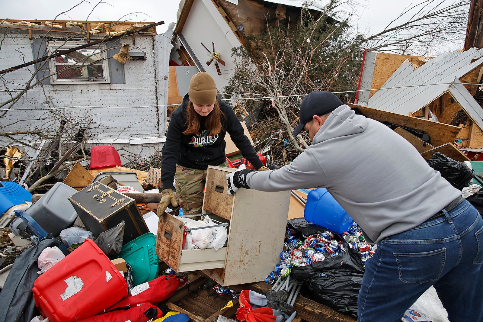 Marc Hurley and his daughter, Jessica, collect some of the items from his step father's mobile home Friday, March 15, 2024 in Midway. BILL LACKEY/STAFF 