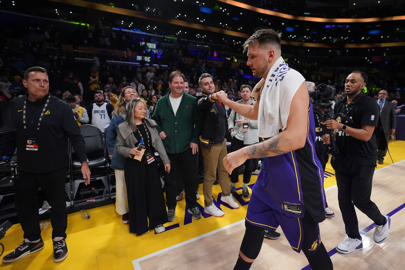 Los Angeles Lakers guard Luka Doncic, second from right, is greeted by a fan as he walks off the court after the team's victory over the Dallas Mavericks in an NBA basketball game Tuesday, Feb. 25, 2025, in Los Angeles. (AP Photo/Mark J. Terrill)