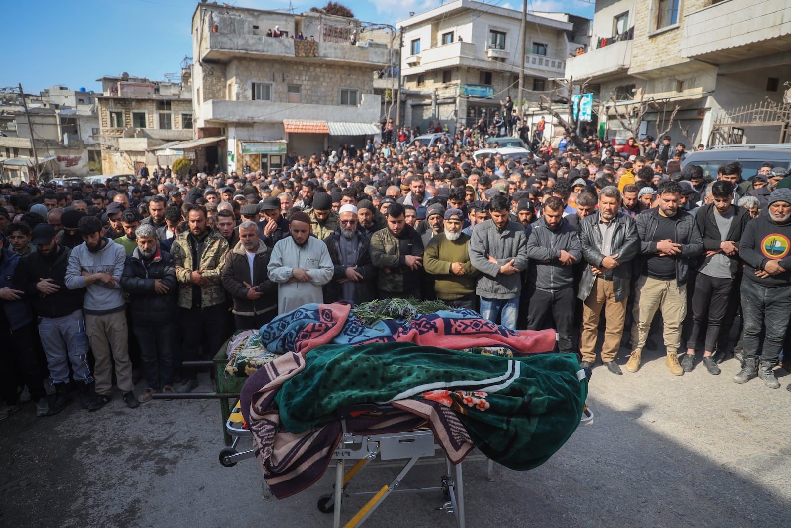 Village male residents pray during the funeral of four Syrian security force members killed in clashes with loyalists of ousted President Bashar Assad in coastal Syria, in the village of Al-Janoudiya, west of Idlib, Saturday, March 8, 2025. (AP Photo/Omar Albam)