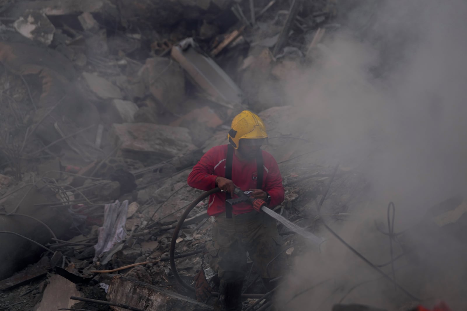 A firefighter extinguishes a fire at the site of an Israeli airstrike that hit central Beirut, Lebanon, Saturday, Nov. 23, 2024. (AP Photo/Hussein Malla)