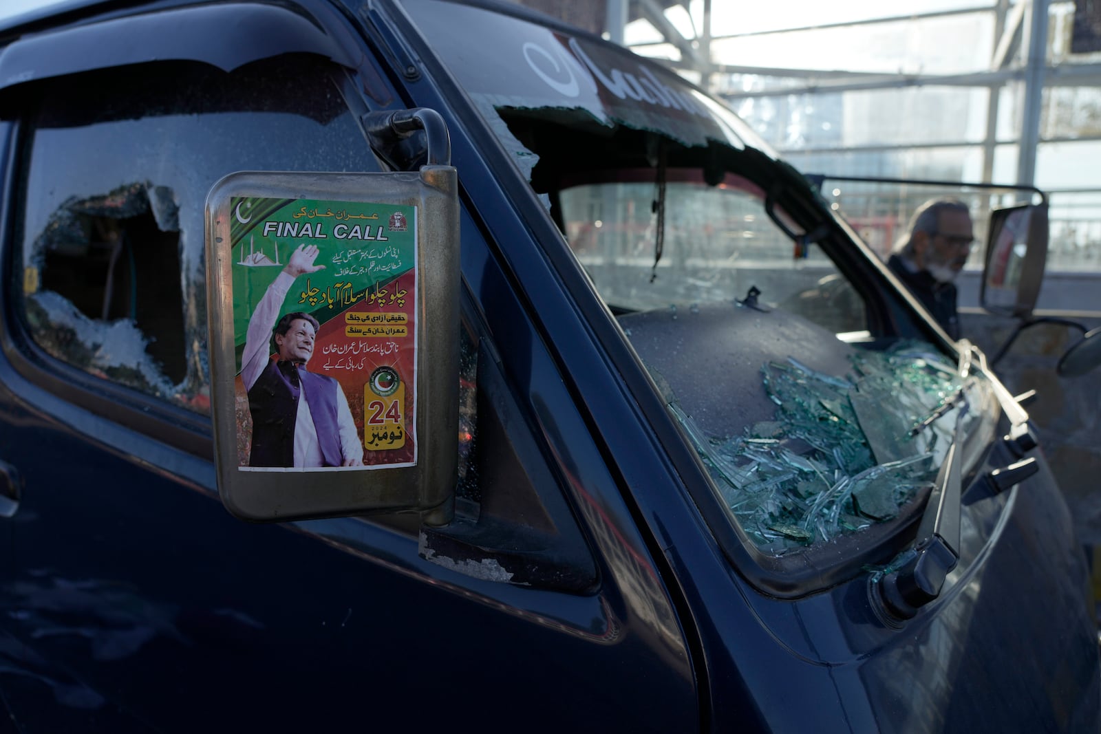 A poster of imprisoned former premier Imran Khan is displayed on a damaged vehicle left behind by supporters of Khan's Pakistan Tehreek-e-Insaf party after clashes with security forces the night before, in Islamabad, Pakistan, Wednesday, Nov. 27, 2024. (AP Photo/Anjum Naveed)