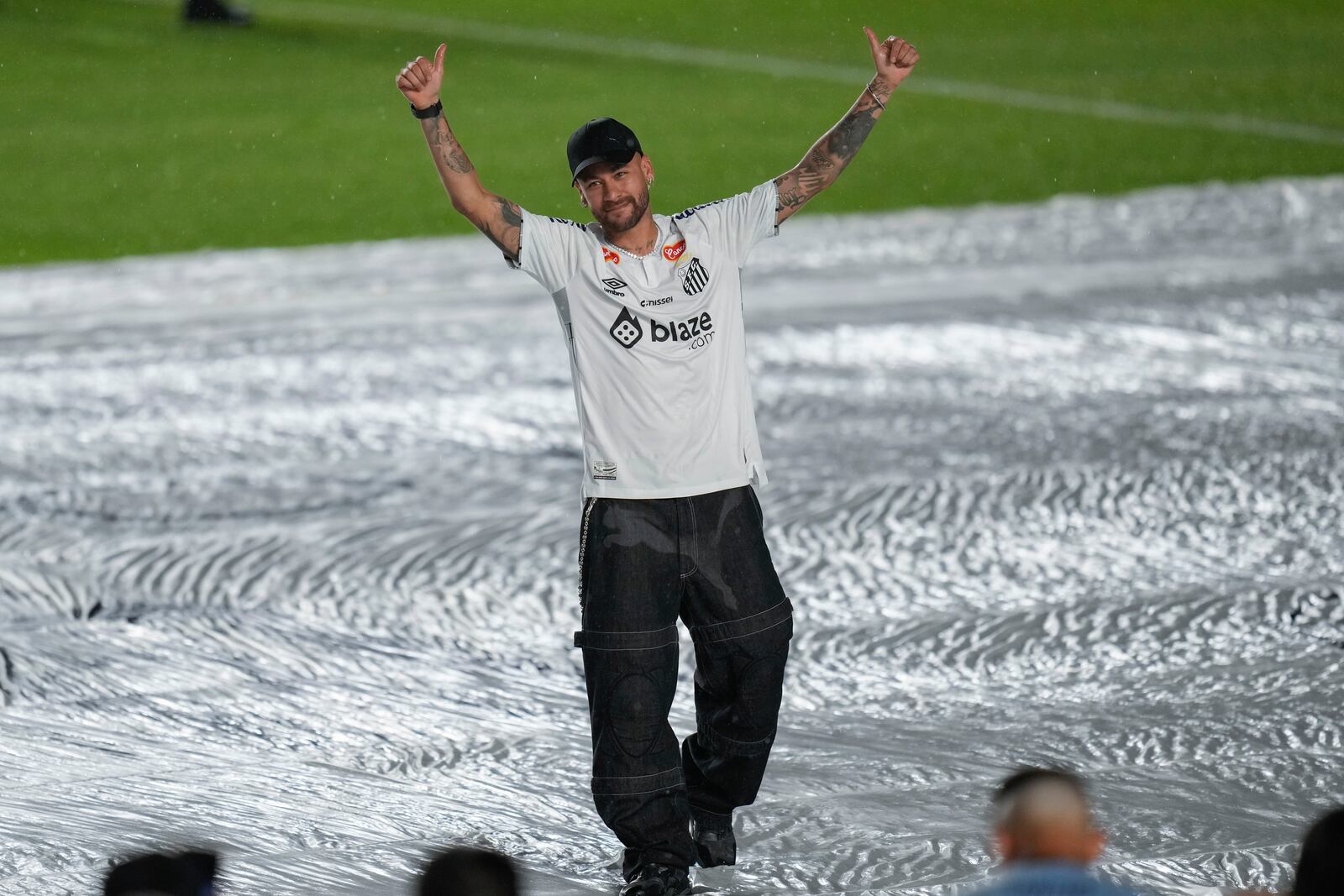 Brazilian soccer player Neymar waves to fans during his presentation ceremony after signing a six-month contract with Santos FC at Vila Belmiro Stadium in Santos, Brazil, Friday, Jan. 31, 2025. (AP Photo/Andre Penner)