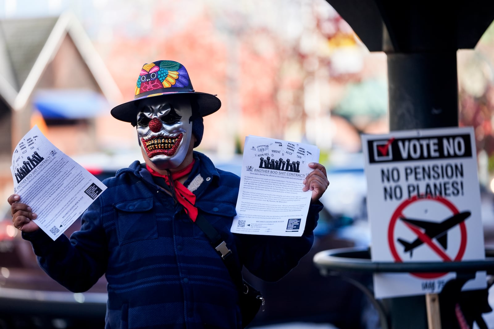 EDS NOTE: OBSCENITY - A Boeing employee holds up flyers encouraging others to vote no on a new contract offer from the company, Monday, Nov. 4, 2024, in Everett, Wash. (AP Photo/Lindsey Wasson)