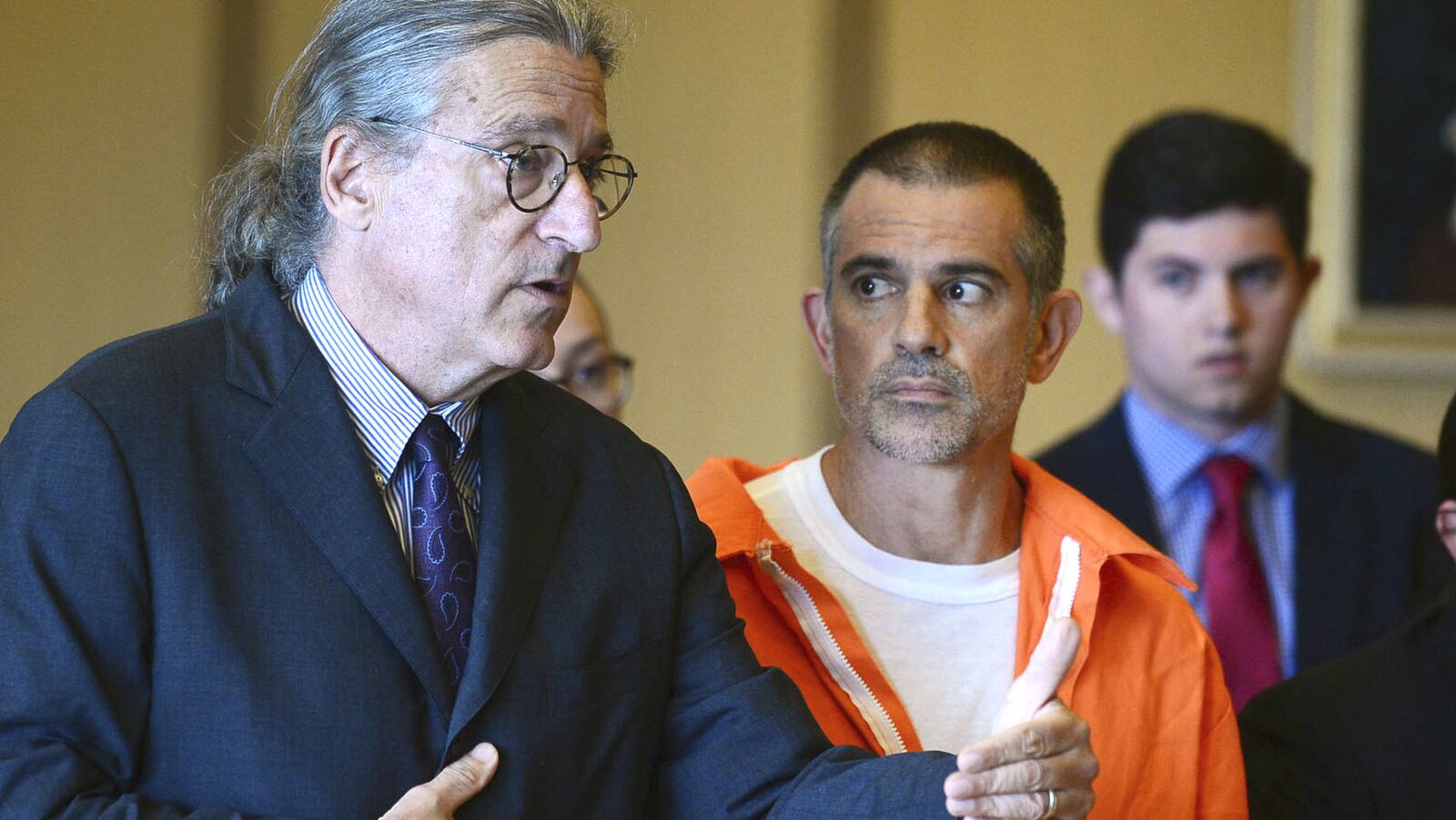 Fotis Dulos, center, listens, as his attorney, Norm Pattis, left, addresses the court during a hearing Tuesday, June 11, 2019, in Stamford, Conn. Fotis Dulos and his girlfriend, Michelle Troconis, have been charged with evidence tampering and hindering prosecution in the disappearance of his wife, Jennifer Dulos. The 50-year-old mother of five has been missing since May 24, 2019.