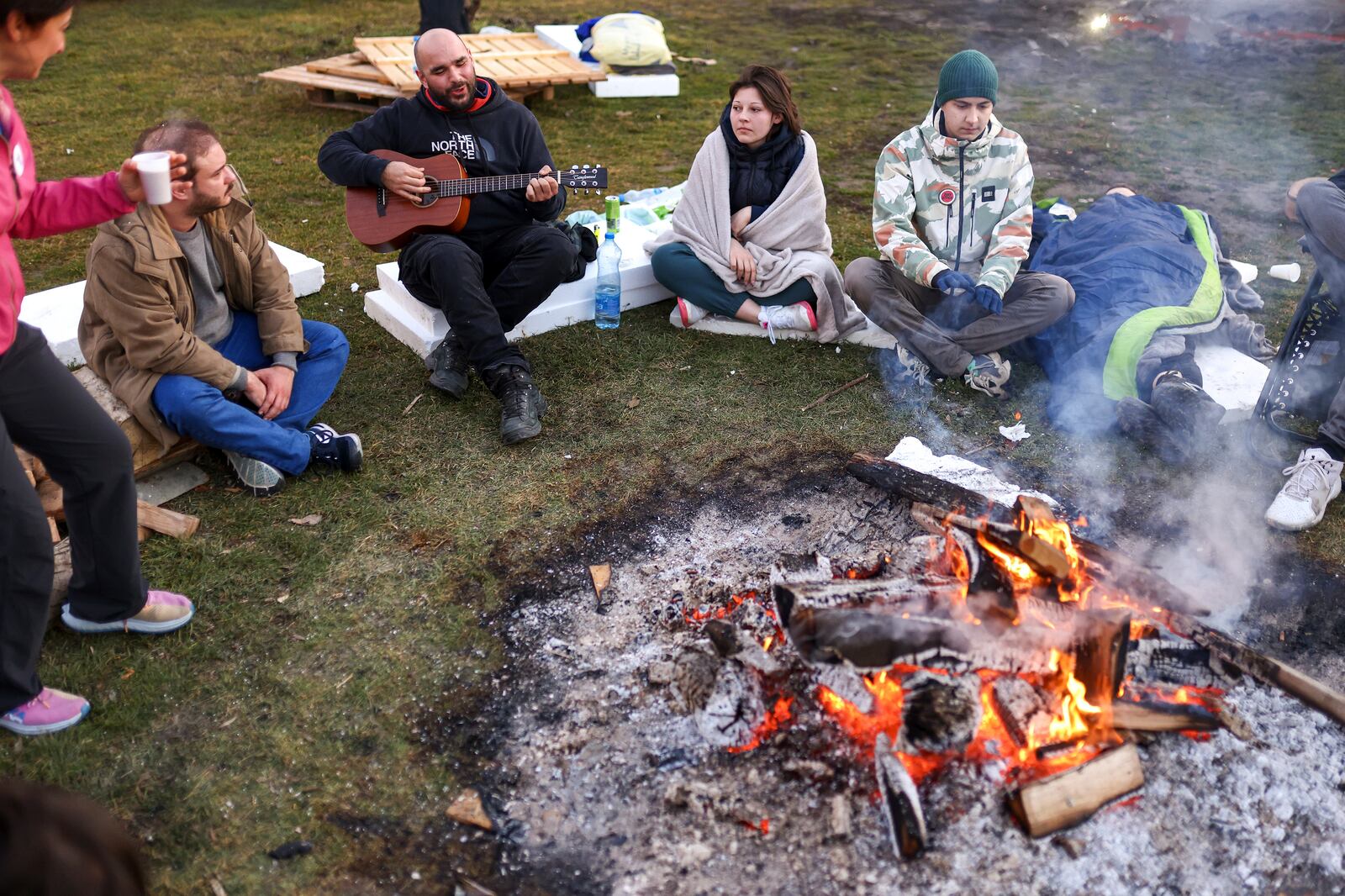 Students sit around a fire as they try to warm up during a protest over the collapse of a concrete canopy that killed 15 people more than two months ago, in Indjija, Serbia, Friday, Jan. 31, 2025. (AP Photo/Armin Durgut)