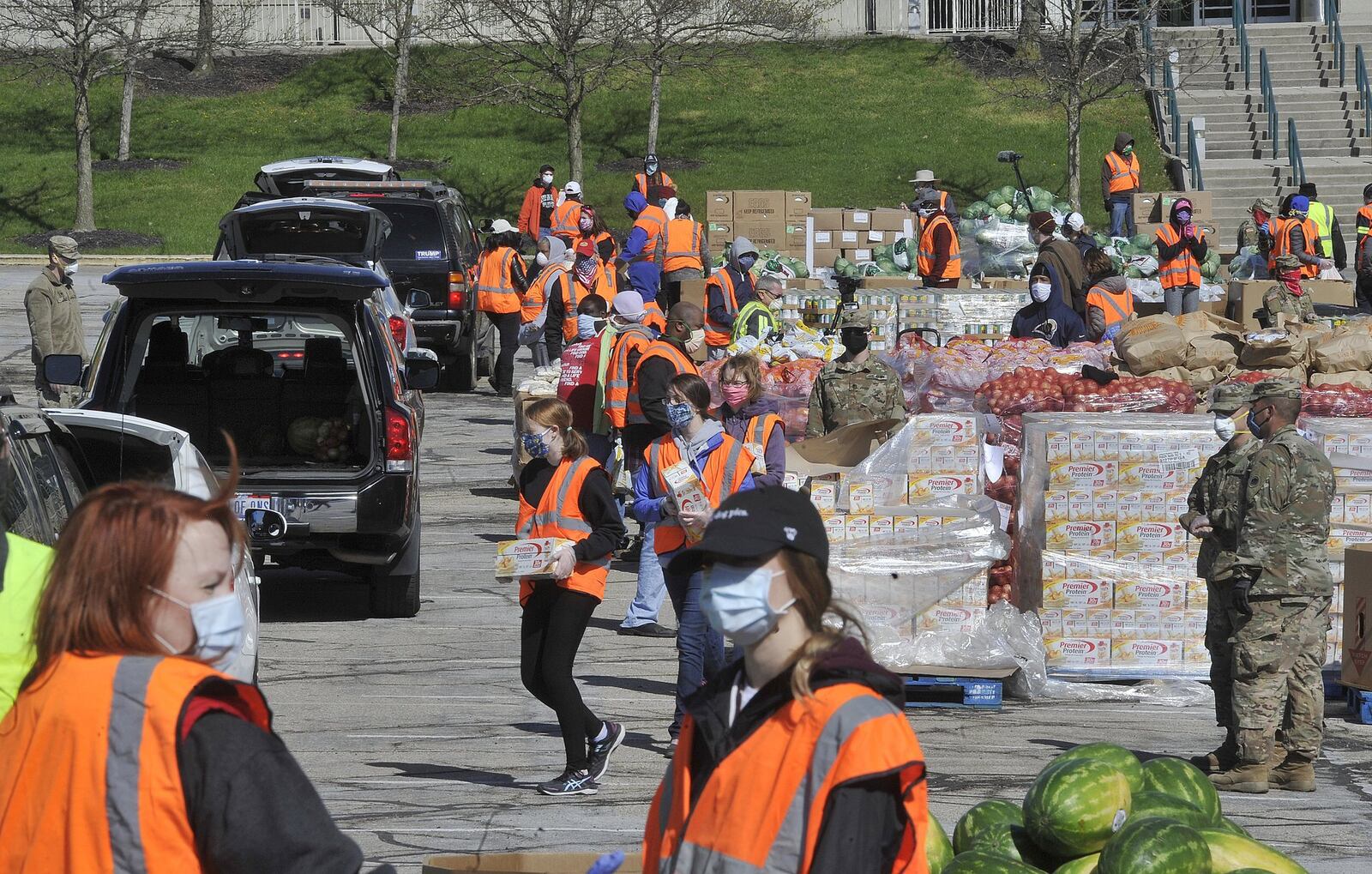 Volunteers and members of the National Guard load food into vehicles at Wright State's Nutter Center on Tuesday morning. The Foodbank was distributing food to Greene County residents. MARSHALL GORBY/STAFF