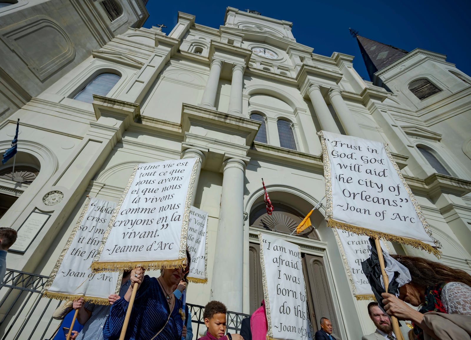 The Krewe de Jeanne d'Arc gather in front of St. Louis Cathedral in New Orleans, Sunday, Jan. 5, 2025, after a mass where Father Patrick Williams spoke of the victims of the New Year's Day deadly truck attack and shooting on Bourbon Street not far from the cathedral in the French Quarter. (AP Photo/Matthew Hinton)