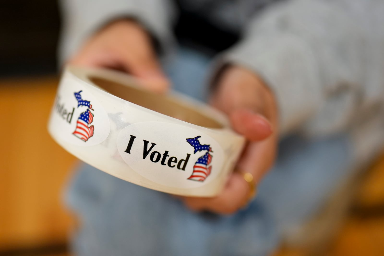 A poll worker holds a roll of "I Voted" stickers at a polling place, Tuesday, Nov. 5, 2024, in Dearborn, Mich. (AP Photo/Charlie Neibergall)