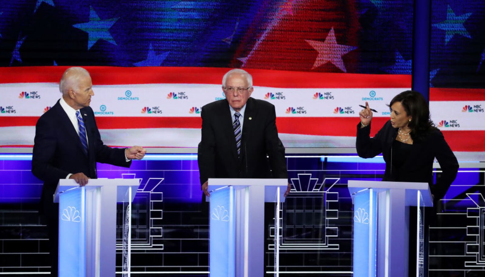 MIAMI, FLORIDA - JUNE 27: Sen. Kamala Harris (R) (D-CA) and former Vice President Joe Biden (L) speak as Sen. Bernie Sanders (I-VT) looks on during the second night of the first Democratic presidential debate on June 27, 2019 in Miami, Florida.  A field of 20 Democratic presidential candidates was split into two groups of 10 for the first debate of the 2020 election, taking place over two nights at Knight Concert Hall of the Adrienne Arsht Center for the Performing Arts of Miami-Dade County, hosted by NBC News, MSNBC, and Telemundo. (Photo by Drew Angerer/Getty Images)