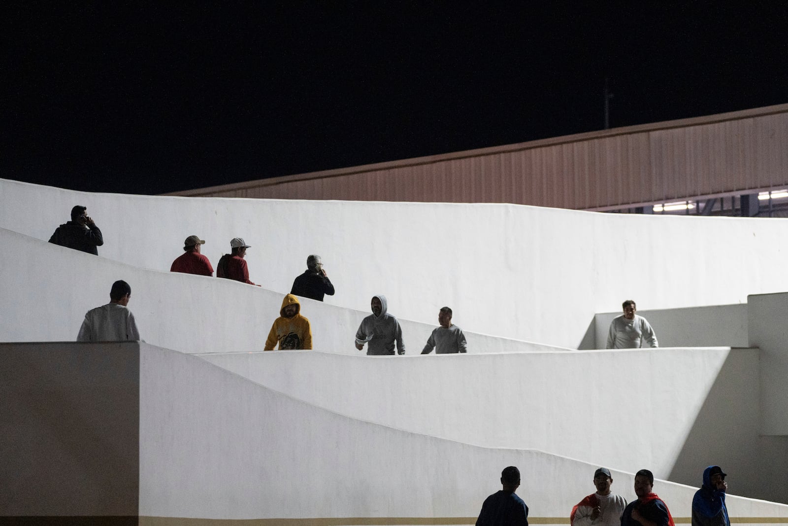 Migrants walk back into Mexico after being deported at El Chaparral pedestrian border bridge in Tijuana, Mexico, Tuesday, Jan. 21, 2025. (AP Photo/Felix Marquez)