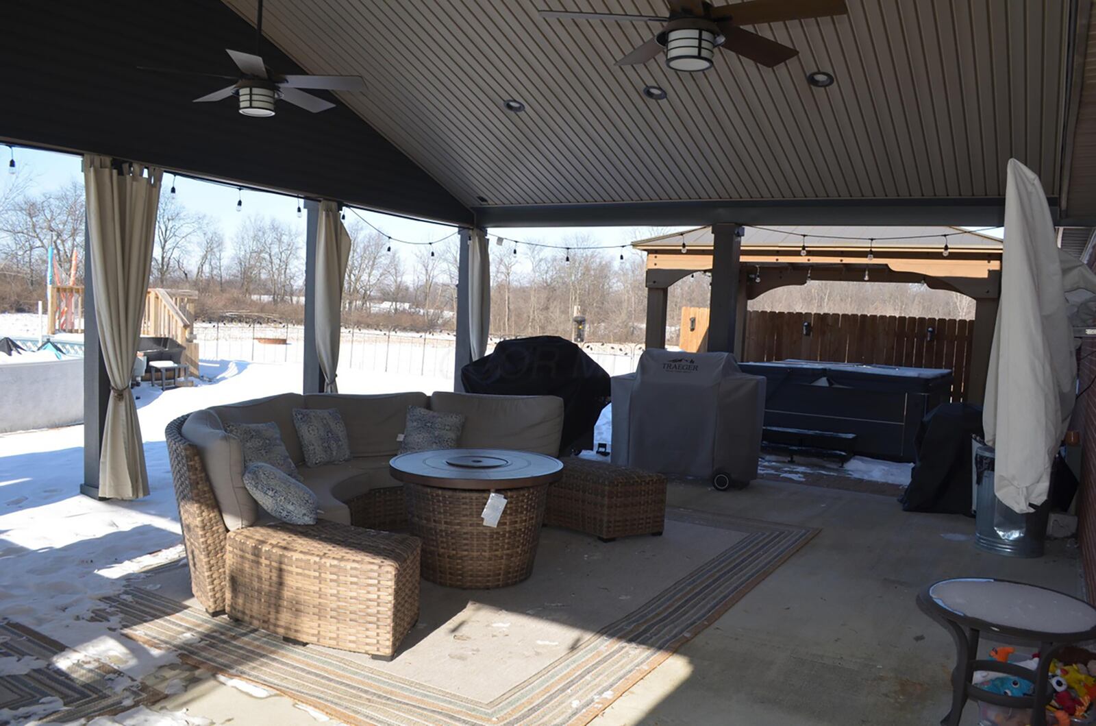 the covered patio has two ceiling fans and recessed lighting