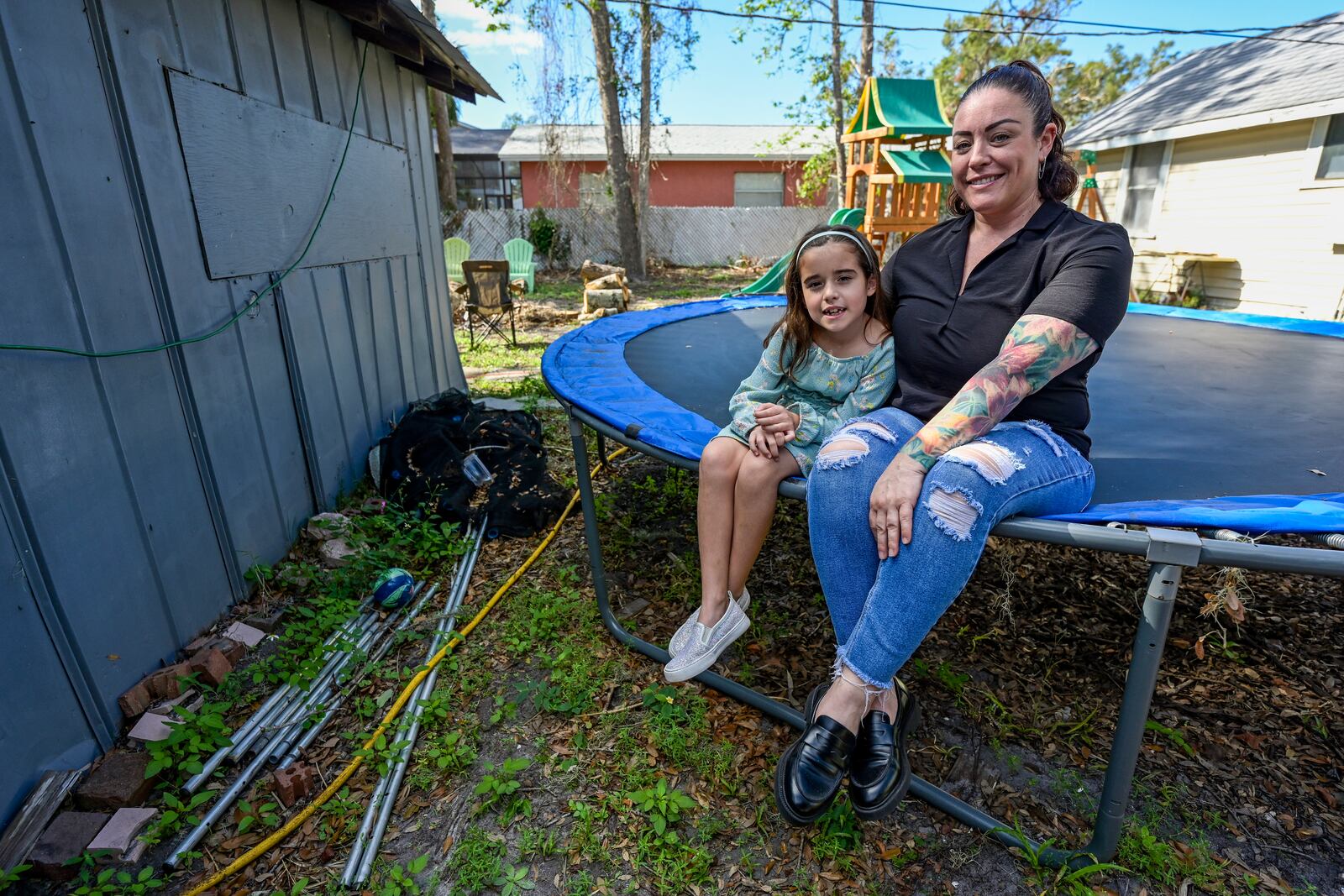 Cecila Grove and her daughter Aria Grove sit outside their home Saturday, Nov. 16, 2024, in Sarasota, Fla. (AP Photo/Steve Nesius)