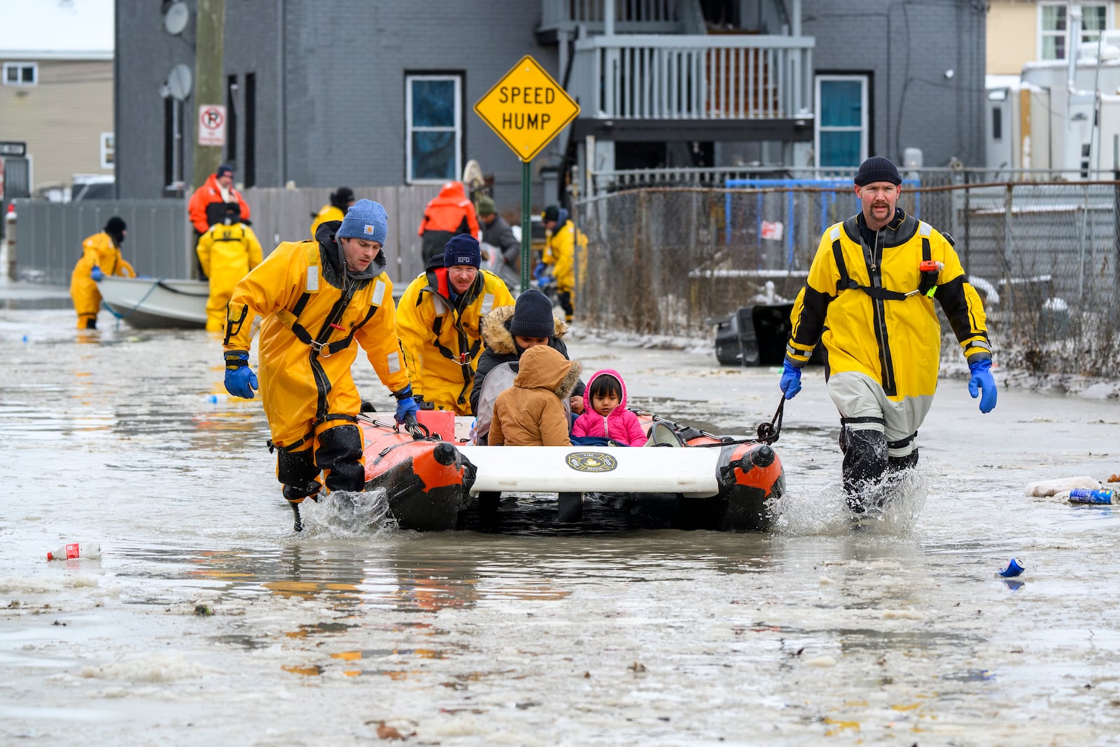 Members of the Downriver Dive Team rescue a family after a water main break in Detroit caused massive flooding, triggering evacuations, Monday, Feb. 17, 2025. (Andy Morrison/Detroit News via AP)