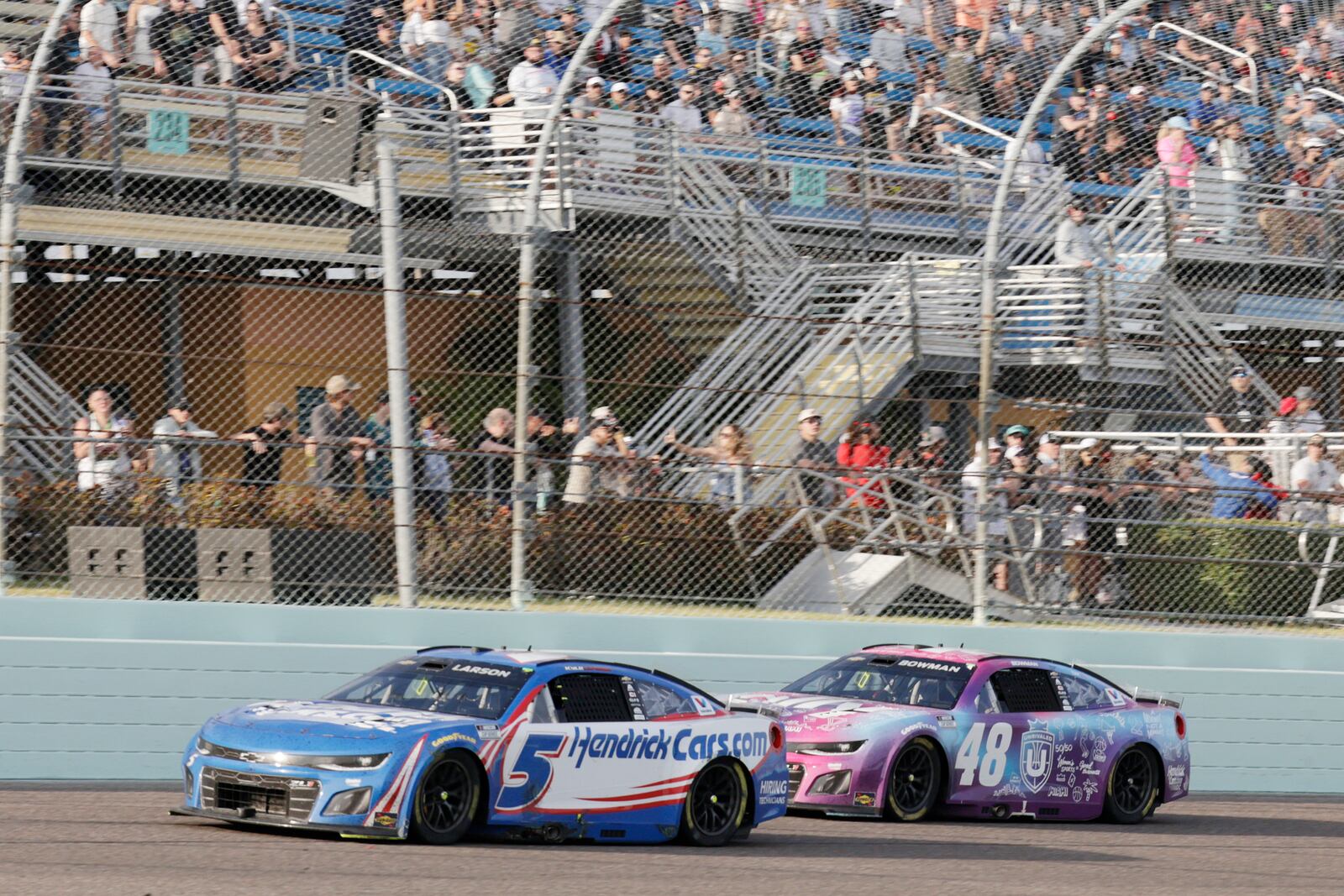 Kyle Larson (5) passes Bubba Wallace (23) to take the lead during a NASCAR Cup Series auto race at Homestead-Miami Speedway in Homestead, Fla., Sunday, March 23, 2025. (AP Photo/Terry Renna)