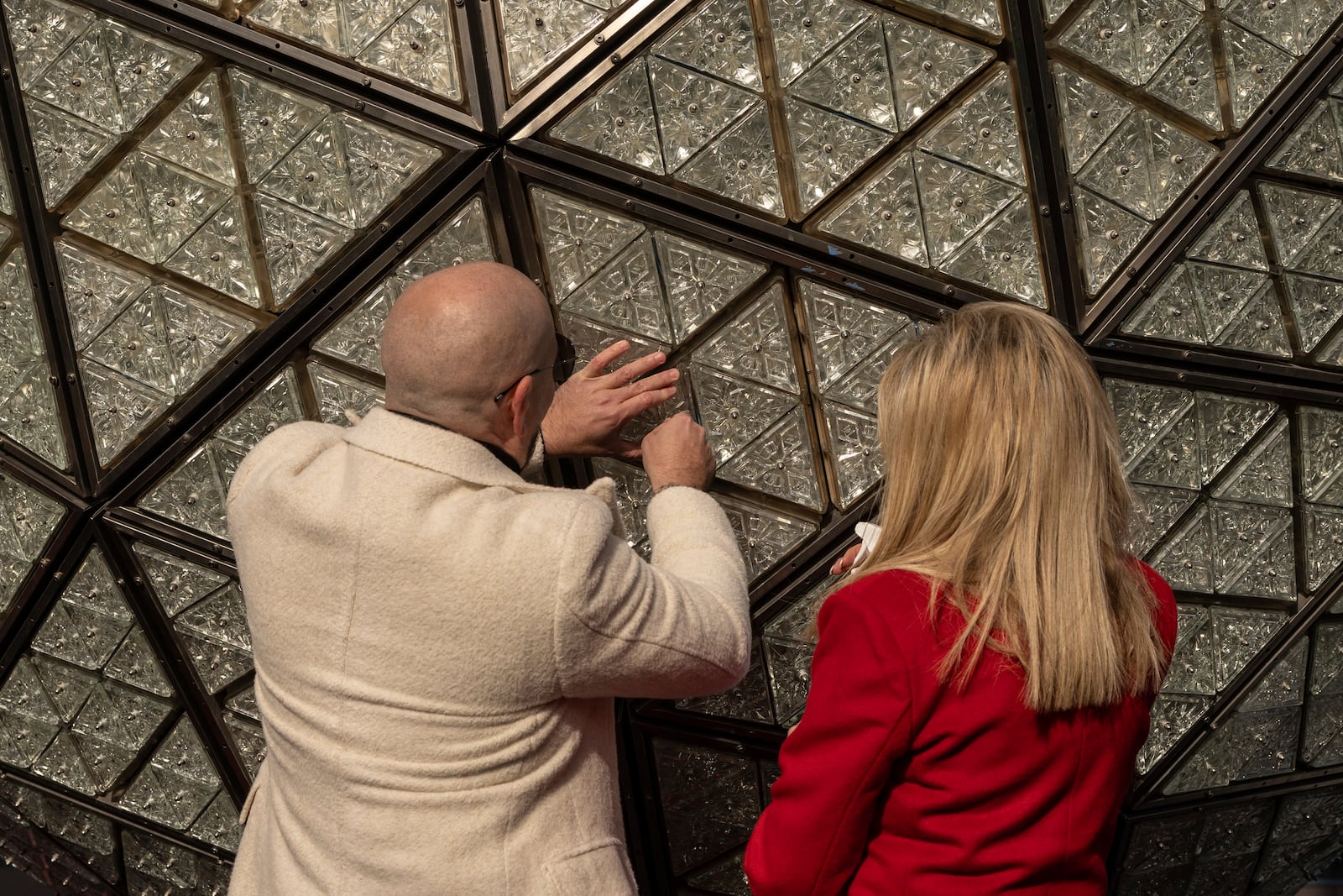 Singer Pitbull, left, and Joy Mangano, right, founder of CleanBoss, install a crystal during the Times Square New Year's Eve Ball Crystal Installation at One Times Square, Friday, Dec. 27, 2024, in New York. (AP Photo/Yuki Iwamura)