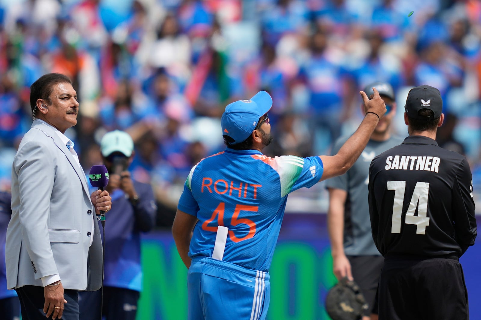 India's captain Rohit Sharma, center, flips the coin at the toss prior to the start of the ICC Champions Trophy final cricket match between India and New Zealand at Dubai International Cricket Stadium in Dubai, United Arab Emirates, Sunday, March 9, 2025. (AP Photo/Altaf Qadri)