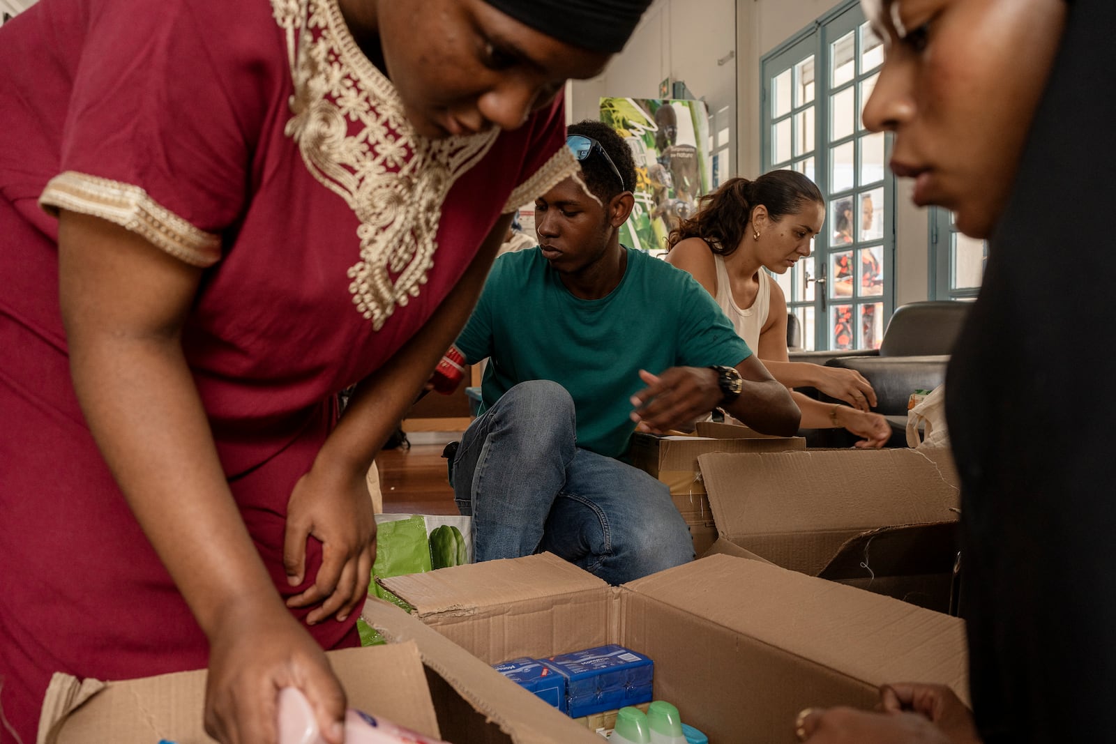 Volunteers sort through donations for victims of cyclone Chido in Mayotte at the House of Mayotte, in Saint-Denis, Réunion Island, Wednesday, Dec. 18, 2024. (AP Photo/Adrienne Surprenant)