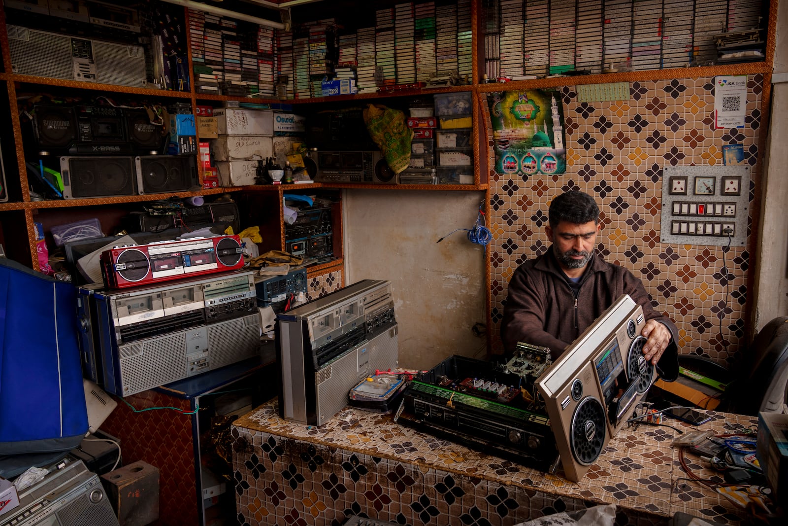 Self-taught tape recorder mechanic Mohammad Ashraf Matoo repairs a tape recorder at his shop in Srinagar, Indian controlled Kashmir, Tuesday, Feb. 11, 2025. (AP Photo/Dar Yasin)