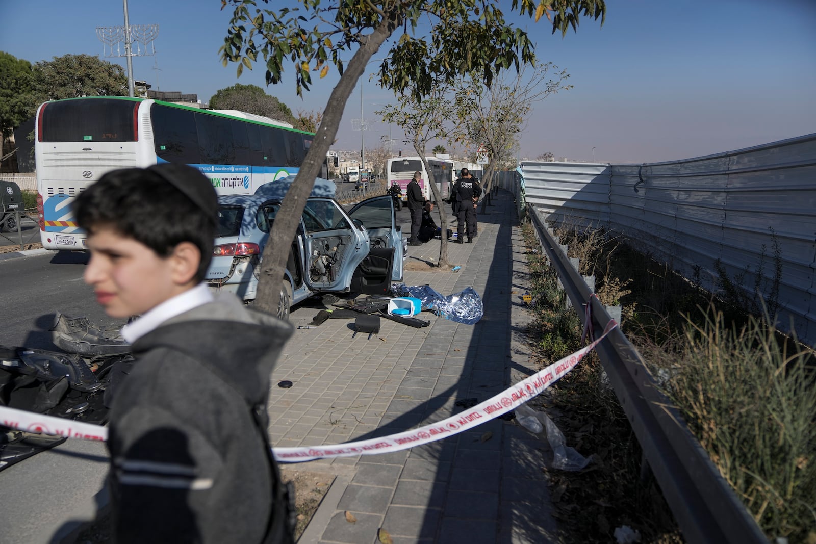 Israel's security officers check a damaged car at the site of an attack in east Jerusalem neighborhood of Pisgat Zeev, Israel, Monday, Dec. 23, 2024. (AP Photo/Mahmoud Illean)