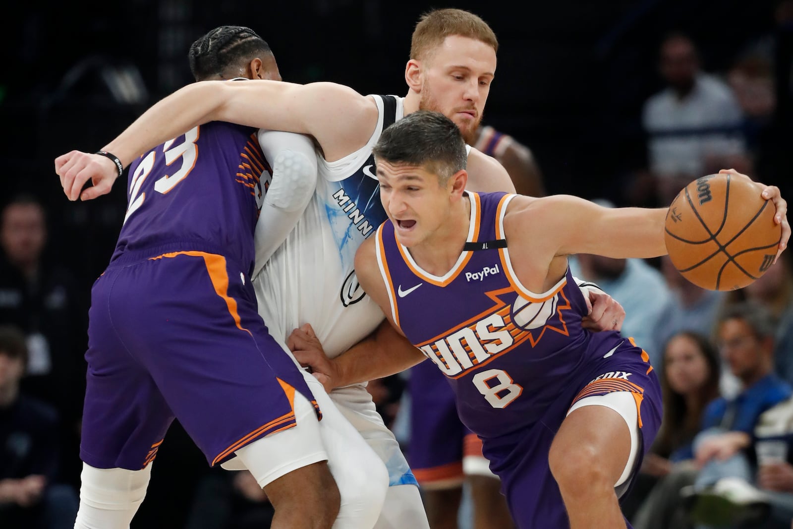 Phoenix Suns guard Grayson Allen (8) works his way around a screen Suns guard Monte Morris (23) set against Minnesota Timberwolves guard Donte DiVincenzo, top right, in the second quarter of an NBA basketball game Sunday, Nov. 17, 2024, in Minneapolis. (AP Photo/Bruce Kluckhohn)