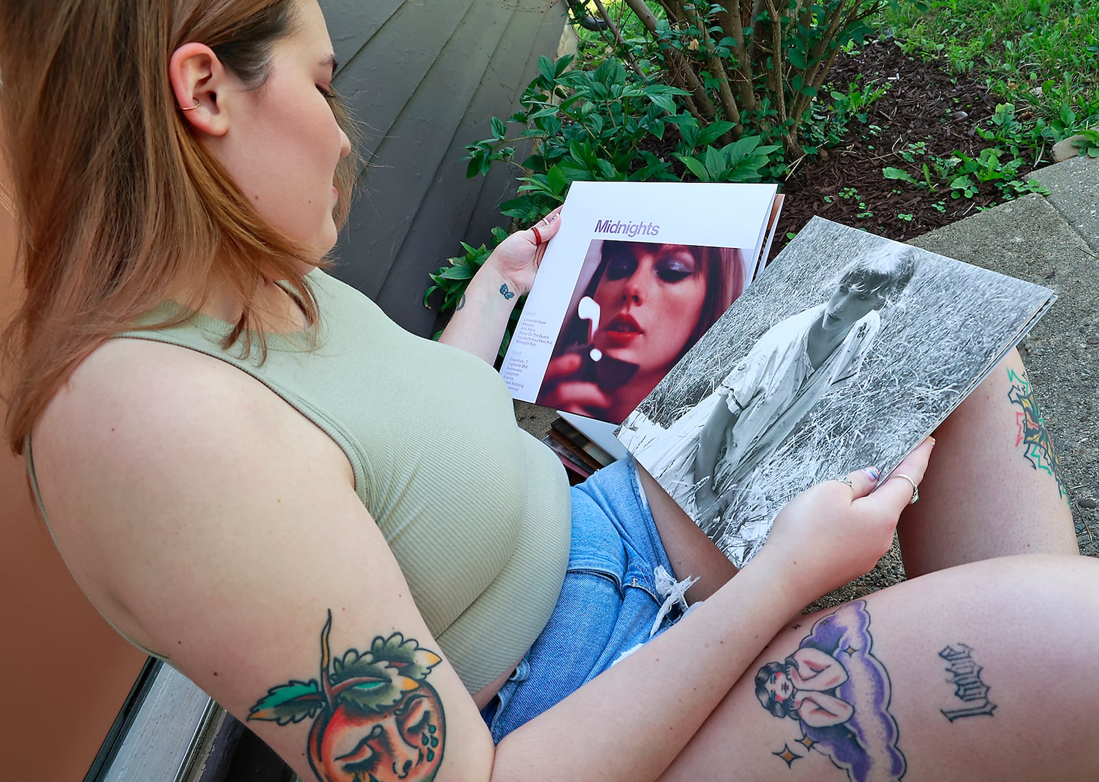 Maggie Bowen, from Springfield, looks through her Taylor Swift album collection Wednesday, June 21, 2023. Bowen is attending the Taylor Swift concert in Cincinnati and another Swift concert in Denver. BILL LACKEY/STAFF