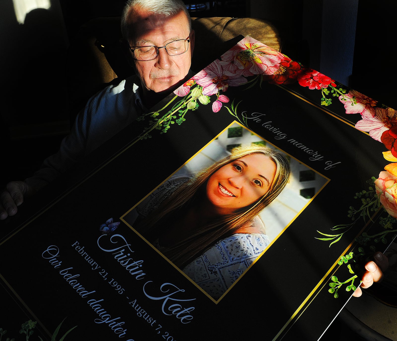 Ron Smith, of Patterson Park, holds a photo of his daughter Tristin Kate Smith, 28, of Dayton, who died by suicide on Aug. 7, 2023. Smith and others have shared a letter written by Tristin that he found on her laptop after her passing, which detailed a difficult working environment in the health care industry. MARSHALL GORBY\STAFF