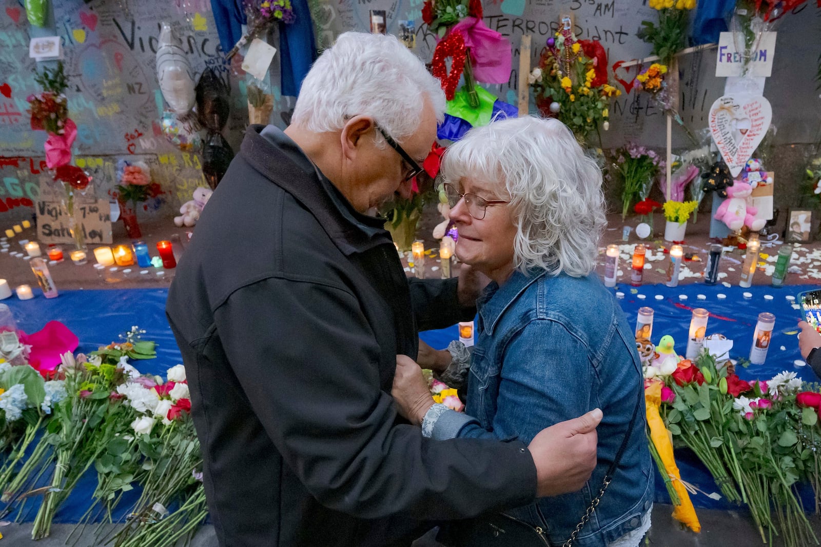 Long Island, New York residents Louis Tenedorio, left, and his wife, Cathy Tenedorio, embrace on by a memorial Bourbon Street and Canal Street in New Orleans, Saturday, Jan. 4, 2025, where their son, Matthew Tenedorio, was killed as one of the victims of the New Year's Day deadly truck attack and shooting. (AP Photo/Matthew Hinton)