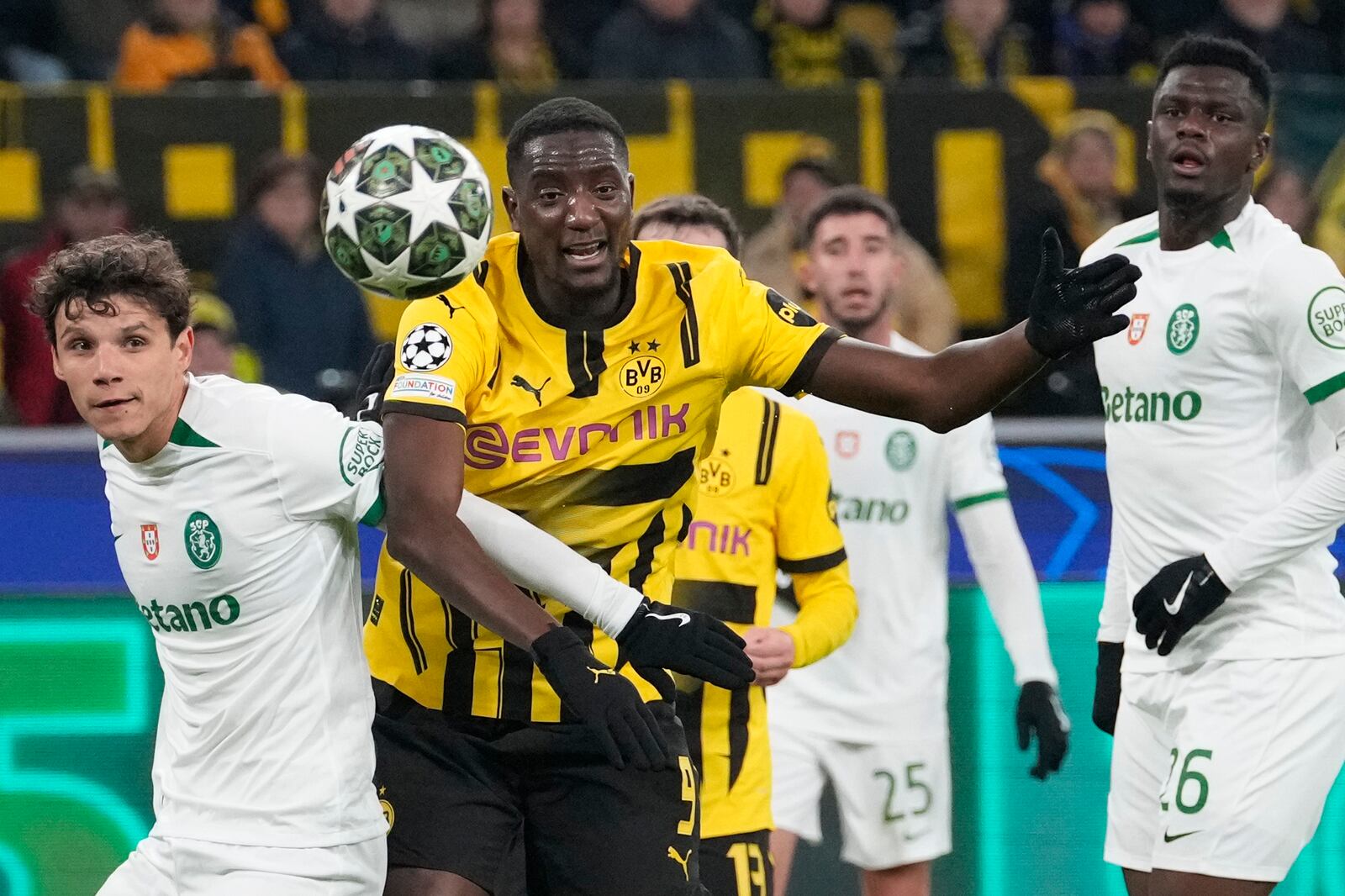 Sporting's Eduardo Quaresma left, and Dortmund's Serhiou Guirassy fight for the ball during the Champions League playoff second leg soccer match between Borussia Dortmund and Sporting CP at the Signa-Iduna Park in Dortmund, Germany, Wednesday, Feb. 19, 2025. (AP Photo/Martin Meissner)