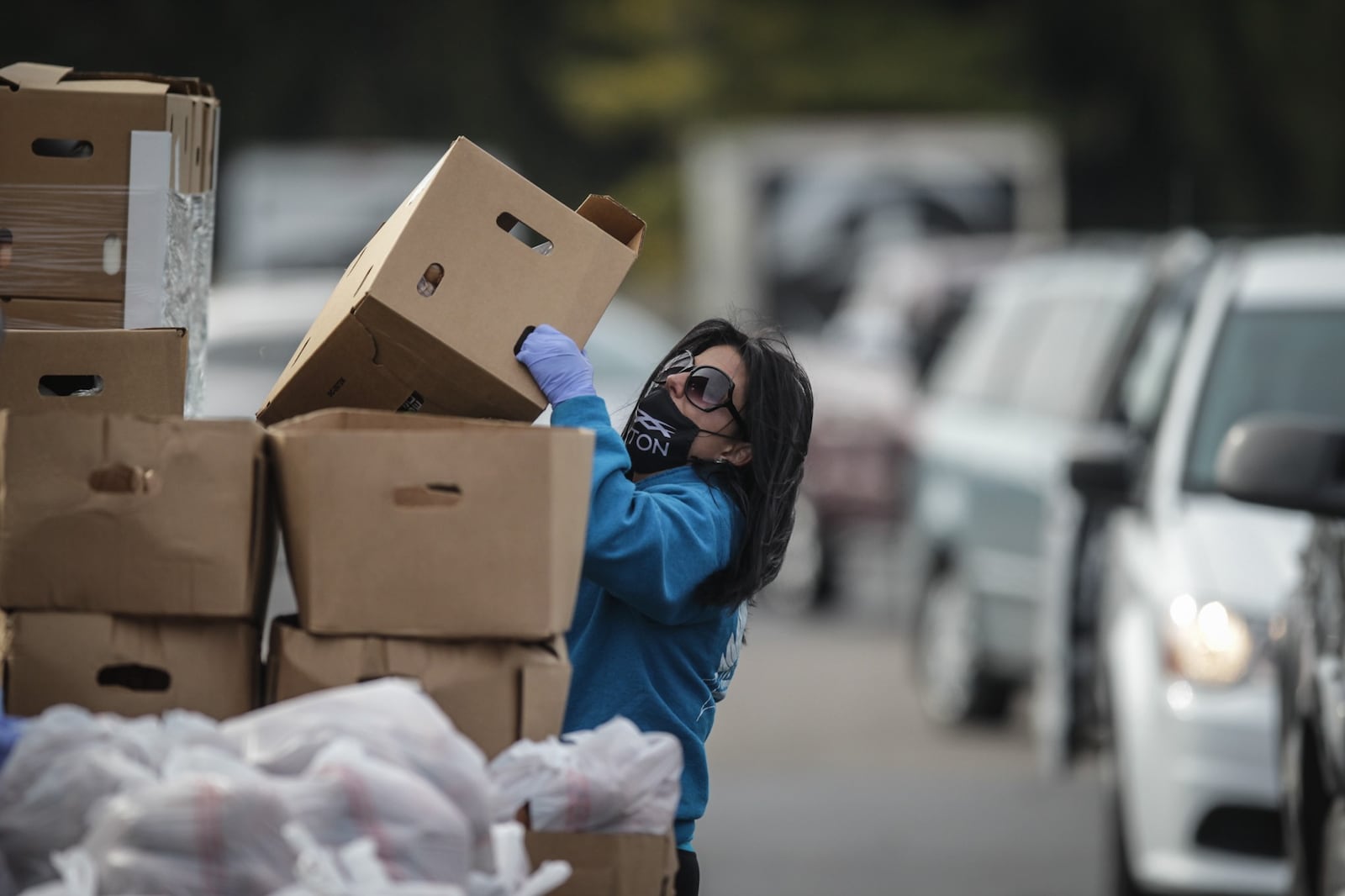 Brandy Halstead moves boxes of food to a vehicle at a food distribution site at Living Word Church in Vandalia.