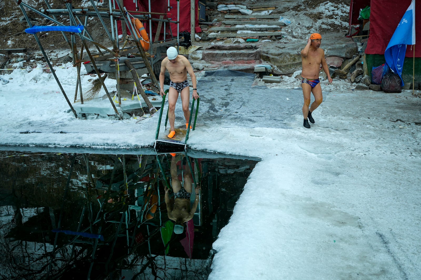 Residents prepare to swim in a pool carved from ice on the frozen Songhua river in Harbin in northeastern China's Heilongjiang province, Tuesday, Jan. 7, 2025. (AP Photo/Andy Wong)