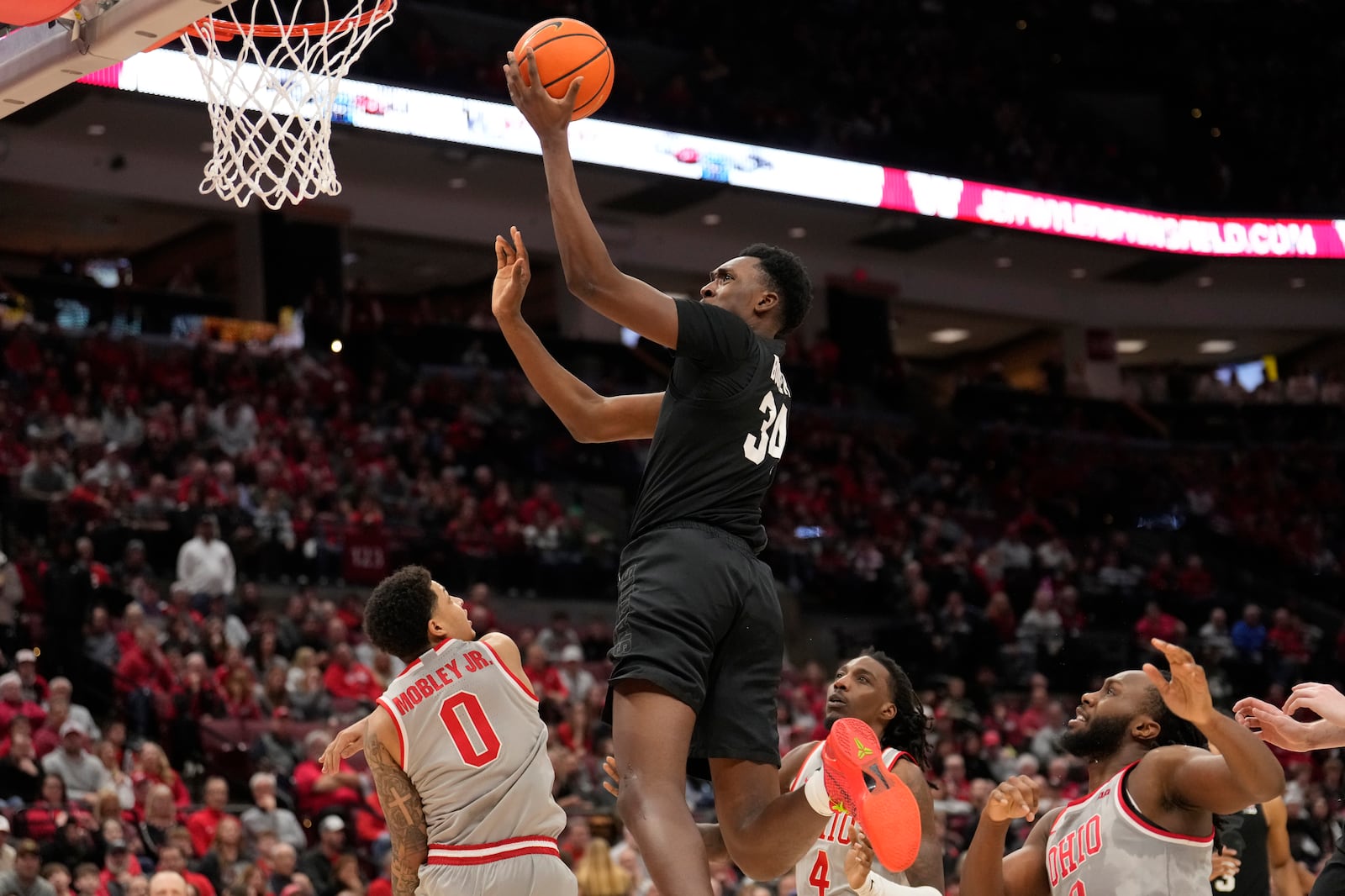 Michigan State forward Xavier Booker (34) shoots between Ohio State guard John Mobley Jr. (0), forward Aaron Bradshaw (4) and guard Bruce Thornton (2) in the second half of an NCAA college basketball game Friday, Jan. 3, 2025, in Columbus, Ohio. (AP Photo/Sue Ogrocki)