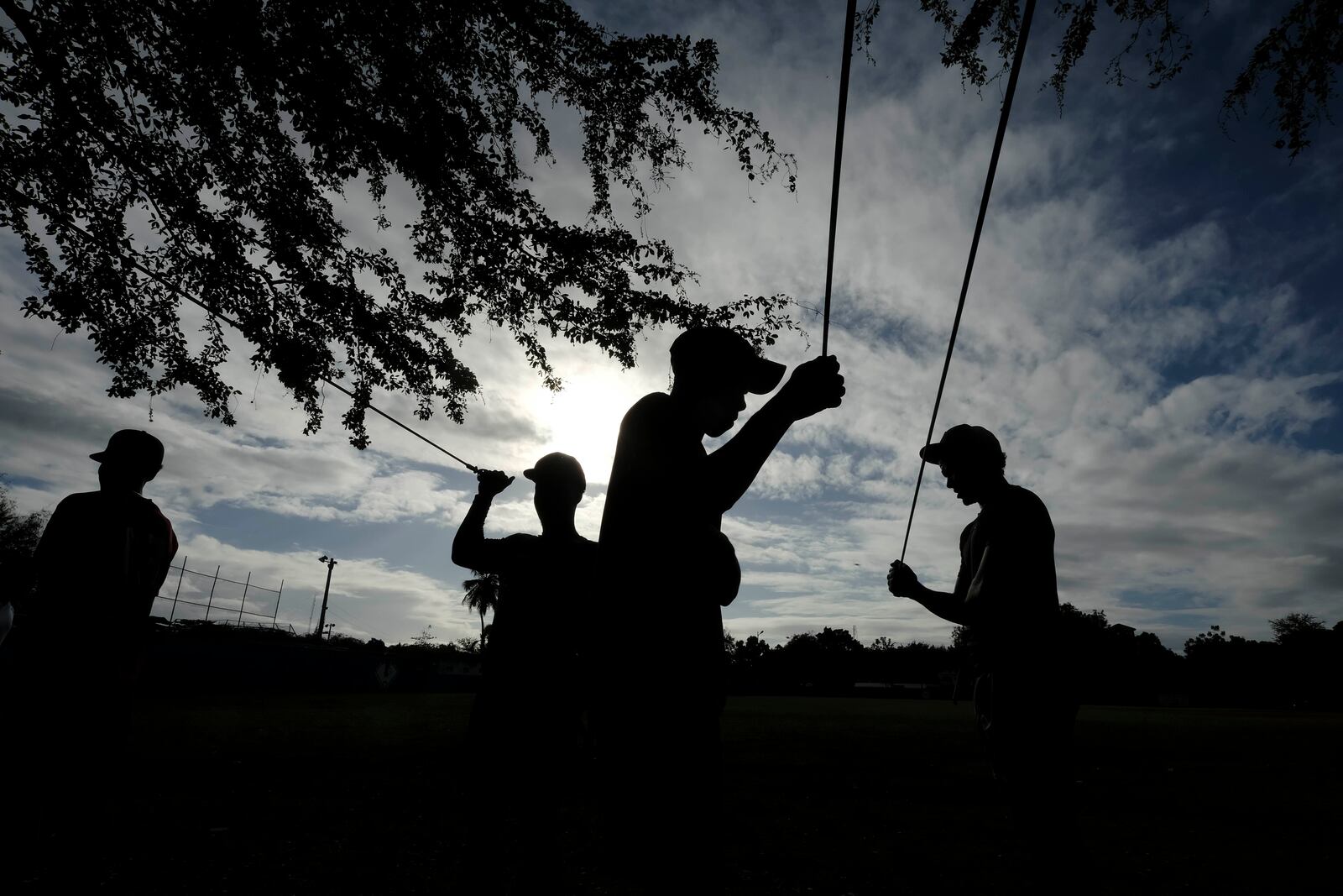 Teenage baseball players pull on resistance bands during their daily training at the Trinitarios ballpark in Santo Domingo, Dominican Republic, Wednesday, Feb. 5, 2025. (AP Photo/Ricardo Hernandez)