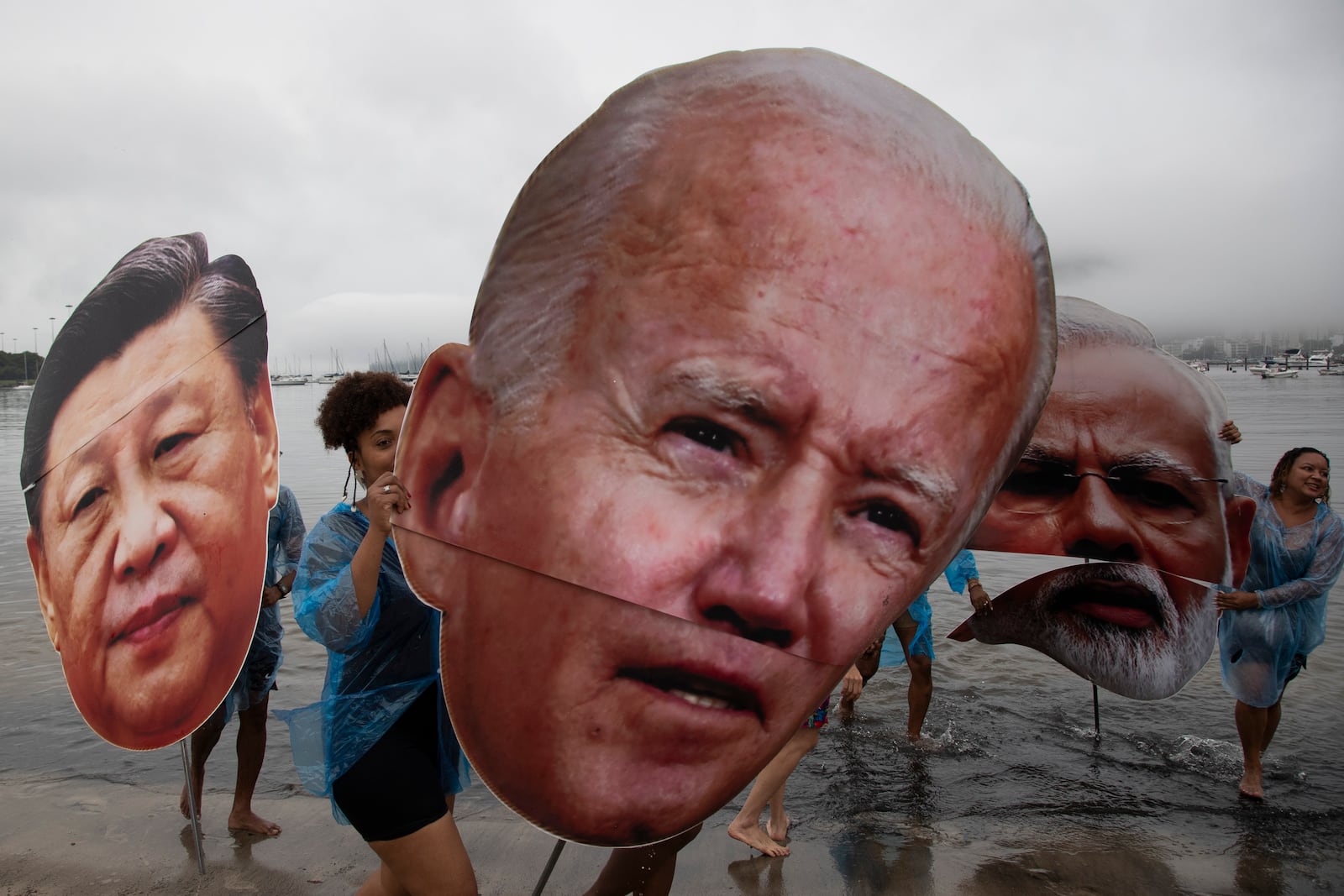 Activists from a Brazilian Indigenous movement hold cutouts of Chinese President Xi Jinping, from left, President Joe Biden and Indian Prime Minister Narendra Modi, during a protest aimed at drawing the attention on the global climate crisis to leaders attending the upcoming G20 Summit, at Botafogo Beach in Rio de Janeiro, Saturday, Nov. 16, 2024. (AP Photo/Bruna Prado)