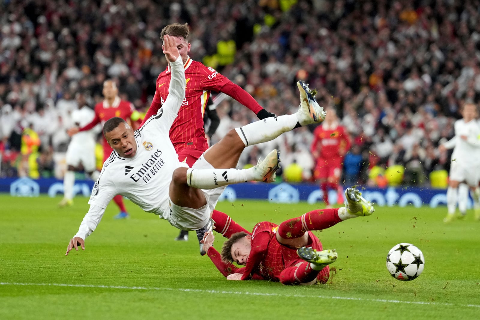 Liverpool's Conor Bradley tackles Real Madrid's Kylian Mbappe, left, during the Champions League opening phase soccer match between Liverpool and Real Madrid at Anfield Stadium, Liverpool, England, Wednesday, Nov. 27, 2024. (AP Photo/Jon Super)