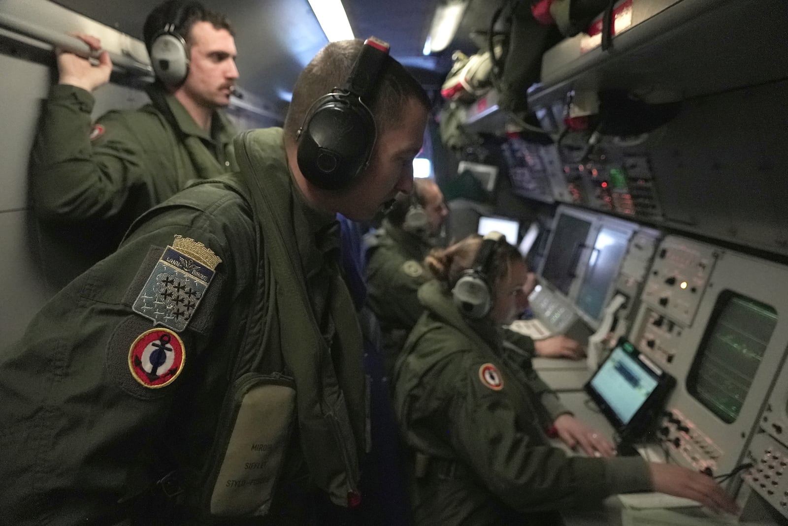 Crew members aboard a French Navy Atlantique 2 surveillance plane watch onboard monitors showing data and images from the aircraft's radars, cameras and other sensors as it patrols Thursday, Jan. 23, 2025, over the Baltic Sea as part of the NATO military alliance's "Baltic Sentry" mission to protect undersea cables and pipelines from sabotage. (AP Photo/John Leicester)