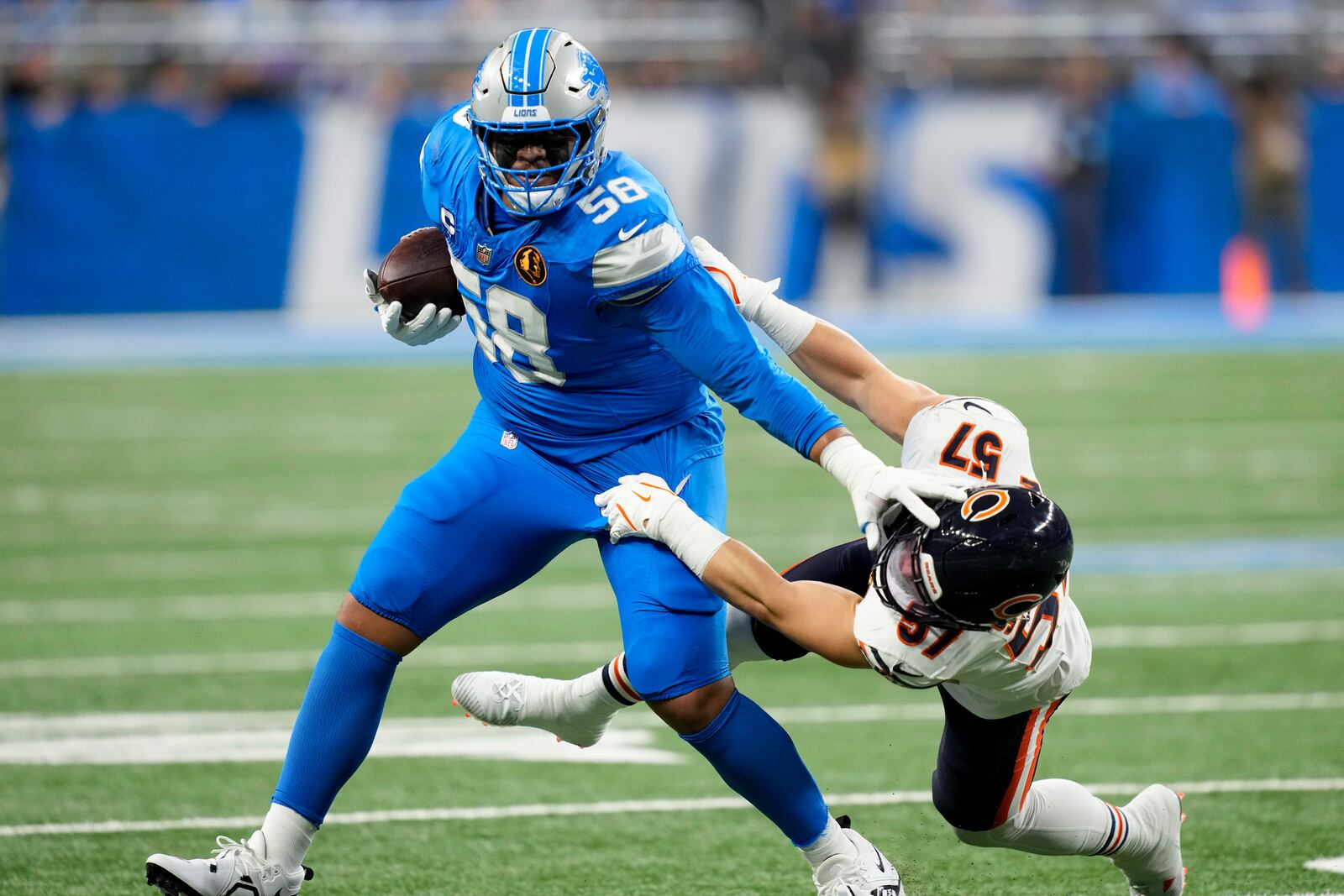 Detroit Lions offensive tackle Penei Sewell (58) sheds the tackle of Chicago Bears linebacker Jack Sanborn (57) during the first half of an NFL football game, Sunday, Nov. 17, 2024, in Detroit. (AP Photo/Carlos Osorio)