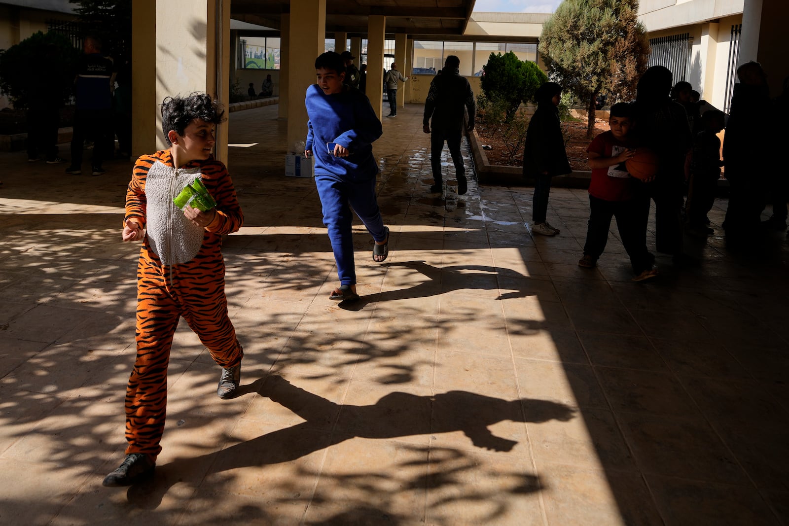 Displaced children, who fled Baalbek city and the nearby towns of Douris and Ain Bourday with their families amid the ongoing Hezbollah-Israel war, play at a school being used as a shelter, in Deir Al-Ahmar, east Lebanon, Thursday, Oct. 31, 2024. (AP Photo/Hassan Ammar)