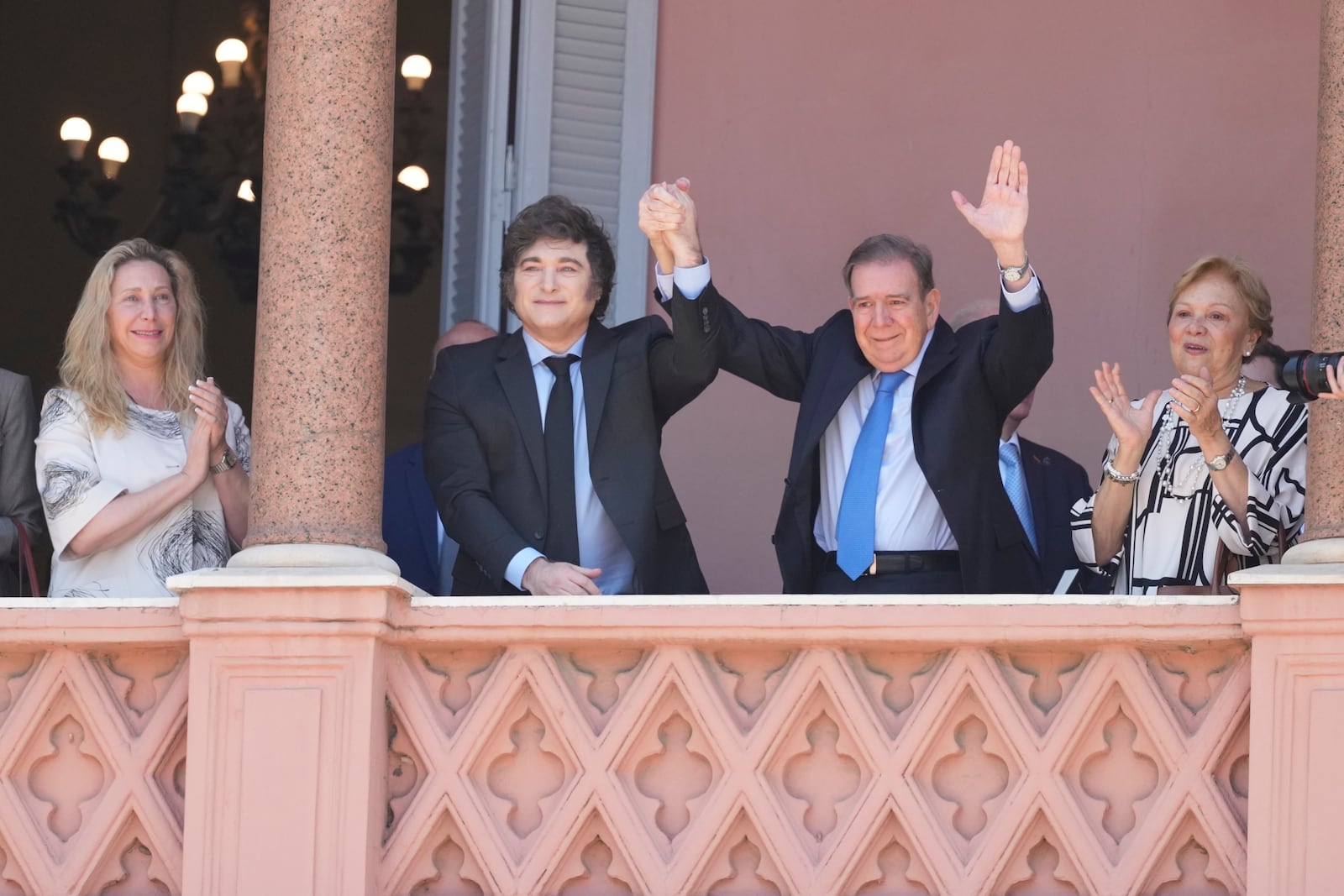 Venezuela's opposition leader Edmundo Gonzalez Urrutia, center right, and Argentine President Javier Milei hold hands from the government house balcony in Buenos Aires, Argentina, Saturday, Jan. 4, 2025. Gonzalez, who claims he won the 2024 presidential election and is recognized by some countries as the legitimate president-elect, traveled from exile in Madrid to Argentina. (AP Photo/Natacha Pisarenko)