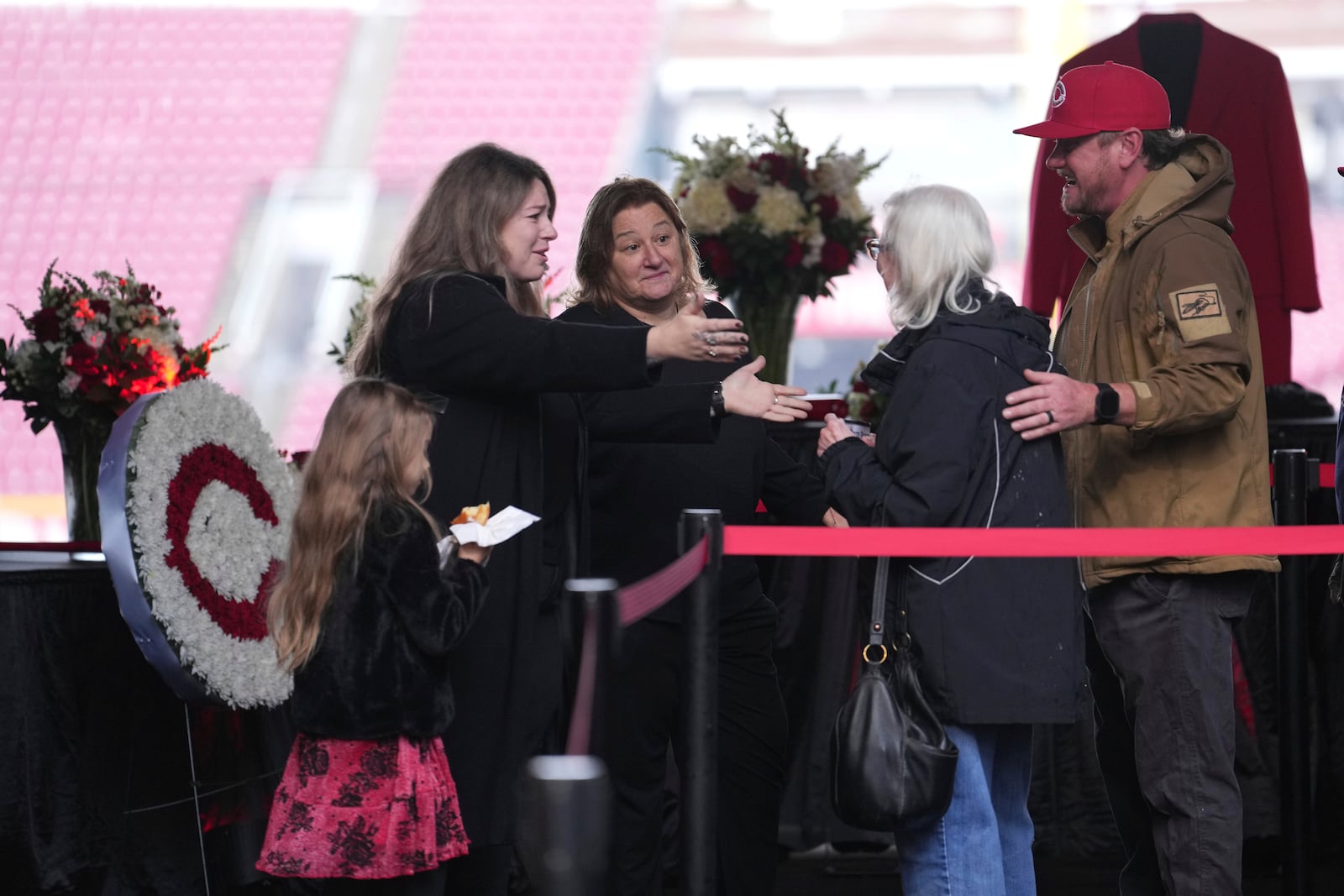 Kara, second from left, and Fawn Rose, center, both daughters of Cincinnati Reds legend Pete Rose, meet baseball fans during a public visitation, Sunday, Nov. 10, 2024, at Great American Ball Park in Cincinnati. (AP Photo/Kareem Elgazzar)