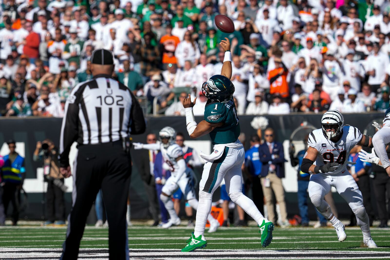 Philadelphia Eagles quarterback Jalen Hurts launches a long touchdown pass to wide receiver DeVonta Smith as Cincinnati Bengals defensive end Sam Hubbard (94) tries to stop him during the second half of an NFL football game, Sunday, Oct. 27, 2024 in Cincinnati. (AP Photo/Jeff Dean)