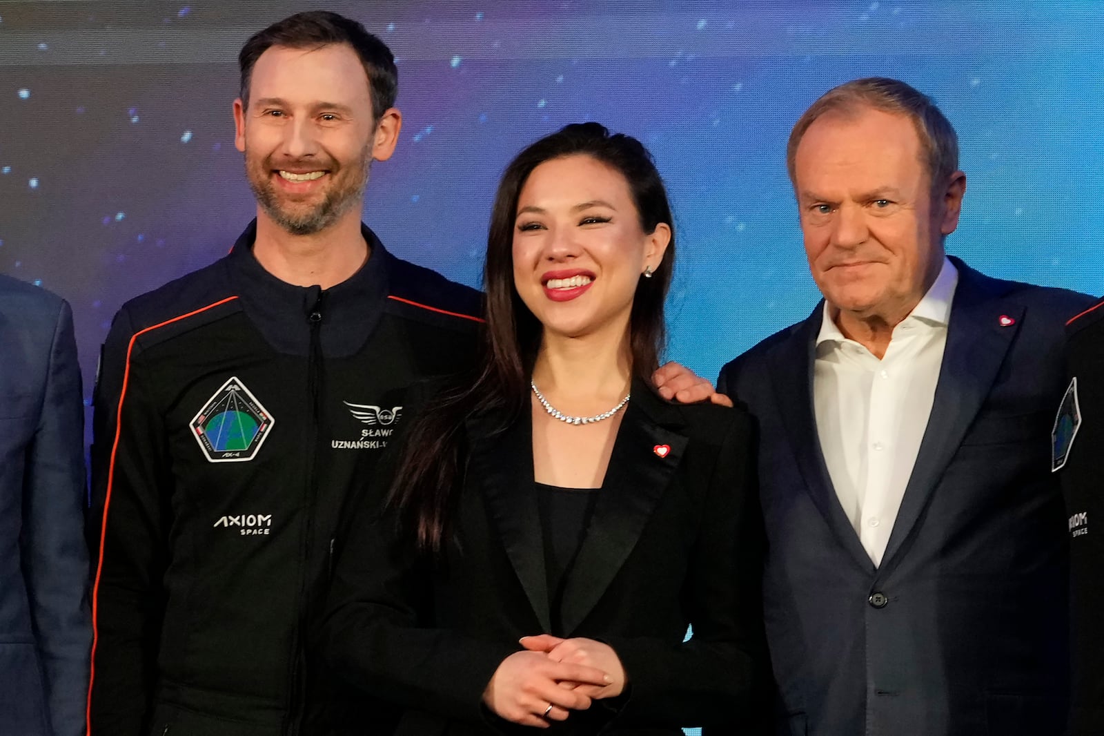 Polish astronaut Slawosz Uznanski-Wisniewski , left, with his wife Aleksandra Uznanska-Wisniewska, center, and Poland's Prime Minister Donald Tusk during a media event dedicated to the preparations for the scientific Ax-4 space mission, at the Copernicus Science Center in Warsaw, Poland, Wednesday, Feb. 5, 2025. (AP Photo/Czarek Sokolowski)