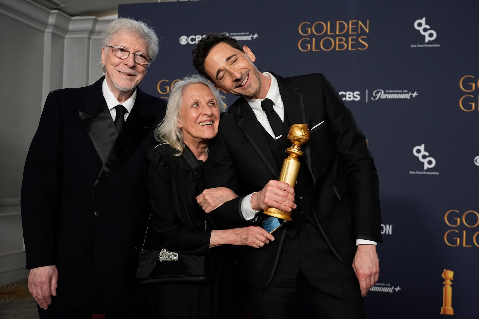 Elliot Brody, from left, Sylvia Plachy, and Adrien Brody, winner of the award for best performance by a male actor in a motion picture drama for "The Brutalist", pose in the press room during the 82nd Golden Globes on Sunday, Jan. 5, 2025, at the Beverly Hilton in Beverly Hills, Calif. (AP Photo/Chris Pizzello)