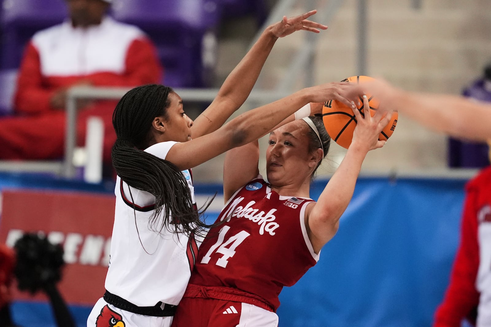 Nebraska guard Callin Hake (14) attempts to make a pass as Louisville's Izela Arenas, left, defends in the first half in the first round of the NCAA college basketball tournament in Fort Worth, Texas, Friday, March 21, 2025. (AP Photo/Tony Gutierrez)