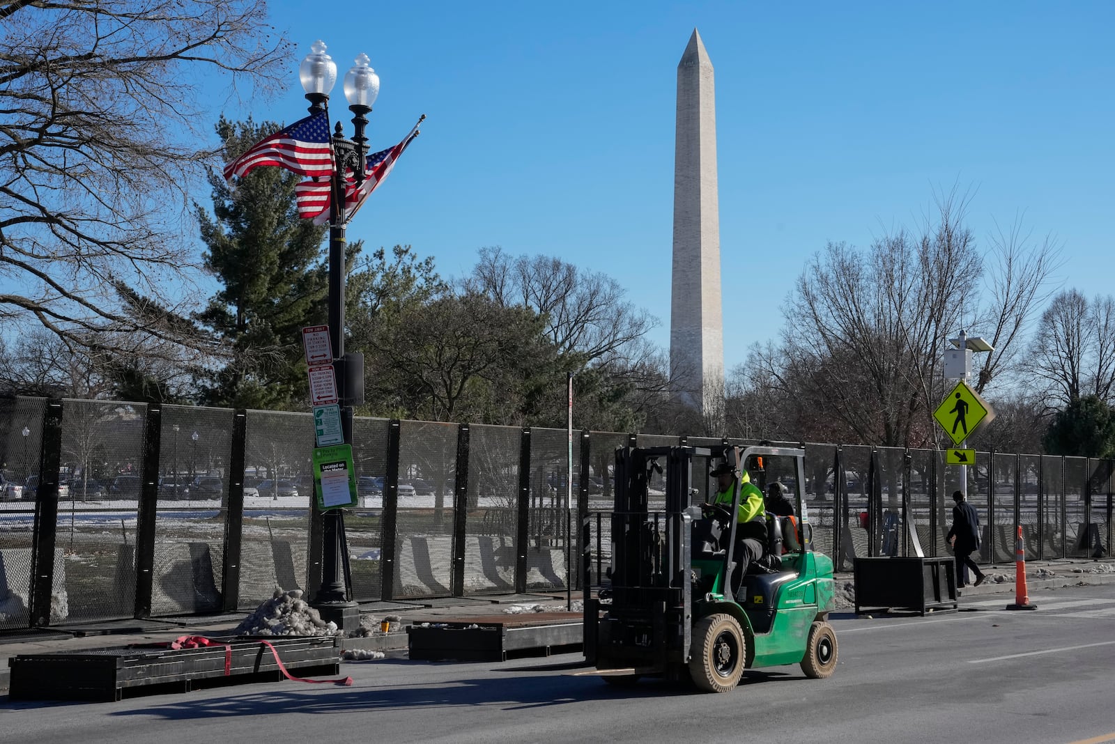 Workers install security fencing around the Ellipse near the White House ahead of the upcoming inauguration of President-elect Donald Trump in Washington, Tuesday, Jan. 14, 2025. (AP Photo/Jon Elswick)