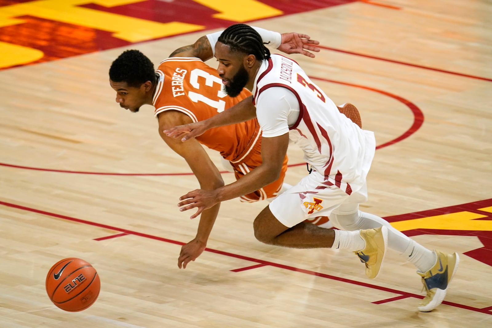 Texas guard Jase Febres (13) fights for a loose ball with Iowa State guard Tre Jackson (3) during the first half of an NCAA college basketball game, Tuesday, March 2, 2021, in Ames, Iowa. (AP Photo/Charlie Neibergall)