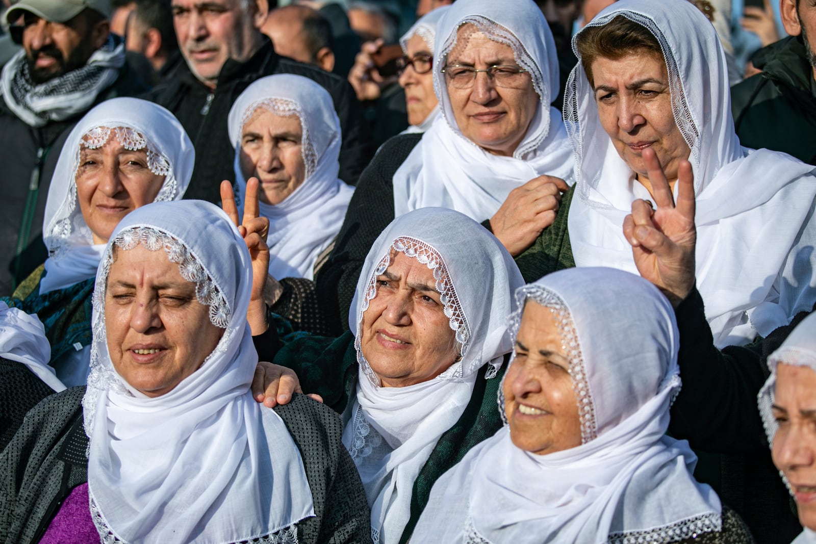 Kurdish women watch live on a tv screen a Pro-Kurdish Peoples' Equality and Democracy Party, or DEM, delegation members releasing an statement from the jailed leader of the rebel Kurdistan Workers' Party, or PKK, Abdullah Ocalan, in Diyarbakir, Turkey, Thursday, Feb. 27, 2025. (AP Photo/Metin Yoksu)