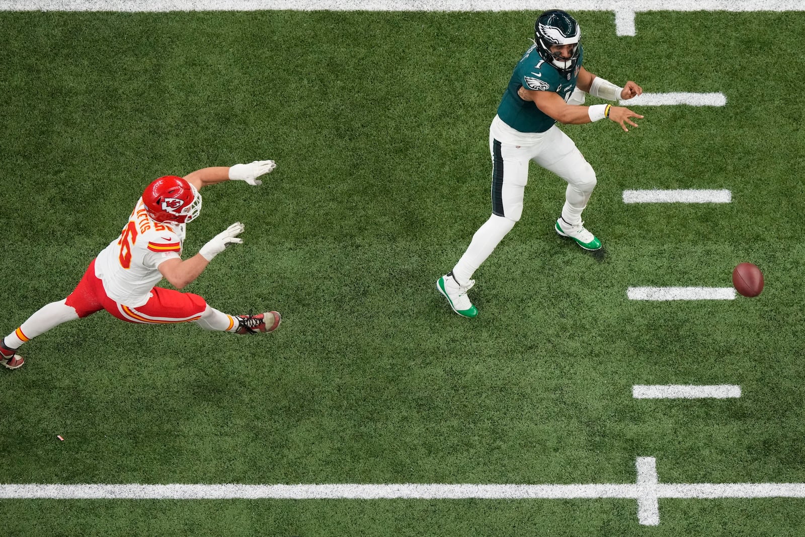 Philadelphia Eagles quarterback Jalen Hurts (1) passes as Kansas City Chiefs defensive end George Karlaftis (56) pressures during the second half of the NFL Super Bowl 59 football game against the Kansas City Chiefs, Sunday, Feb. 9, 2025, in New Orleans. (AP Photo/Godofredo A. Vásquez)