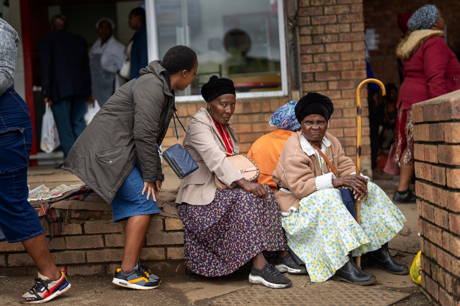 Women sit at the market in Umzimkhulu , South Africa, Wednesday, Nov. 12, 2025, in an area where one of millions of patients in South Africa affected by U.S. President Donald Trump's global foreign aid freeze, raising worry about HIV patients defaulting on treatment. (AP Photo/Jerome Delay)